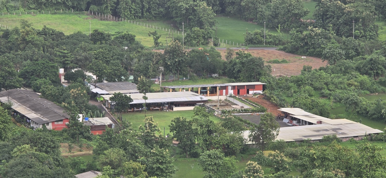 Aerial view of Raj Farm Stay Resort surrounded by greenery
